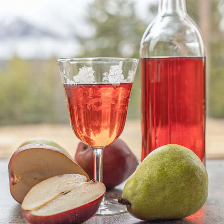 pear wine in a glass and bottle with pears around it.