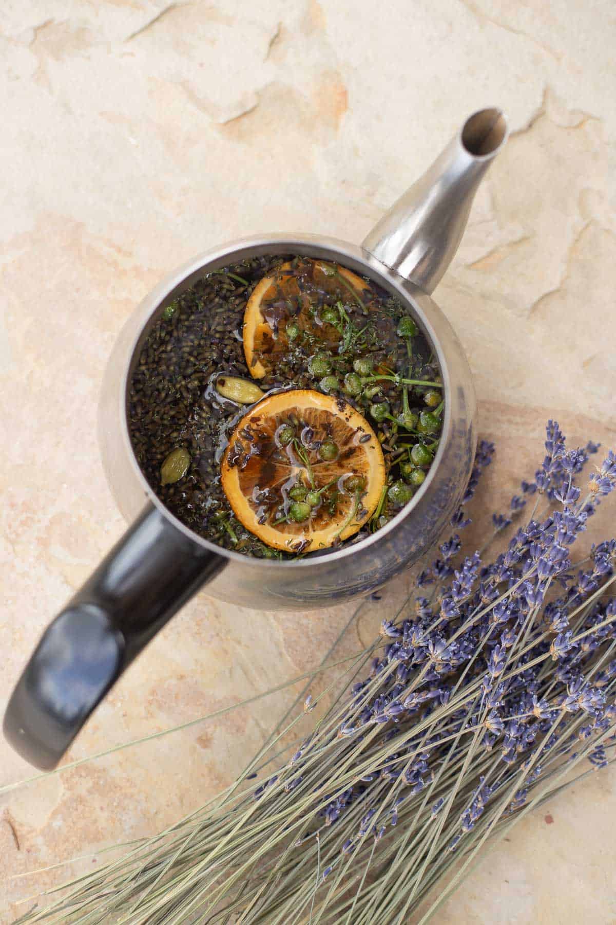 steeping lavender tea in a tea kettle with lavender next to it. 
