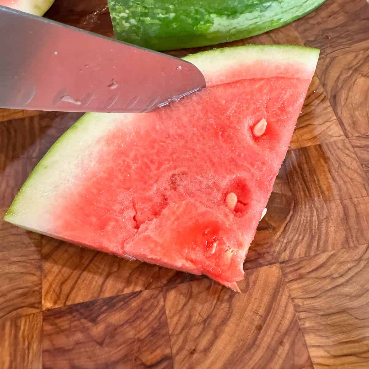 slicing rind off of watermelon.