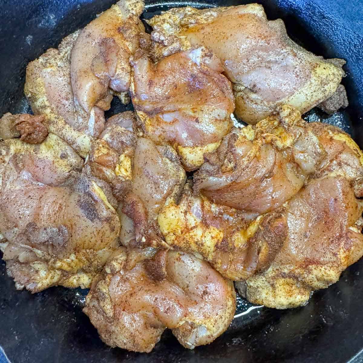 raw chicken thighs in a pan.
