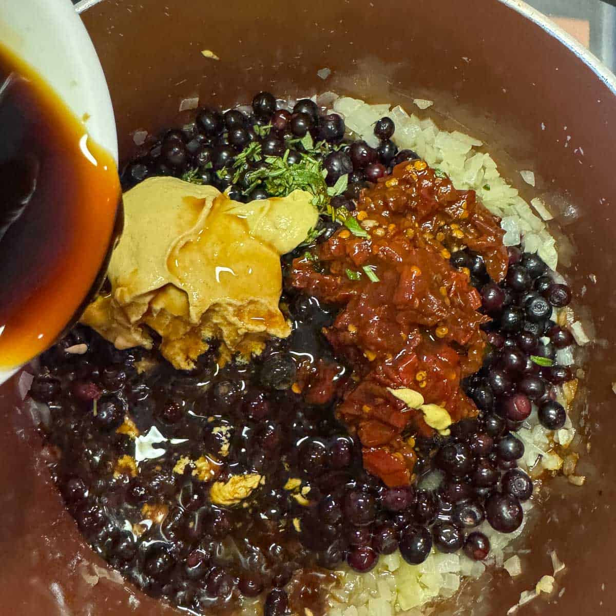 adding balsamic vinegar to huckleberry chicken ingredients.