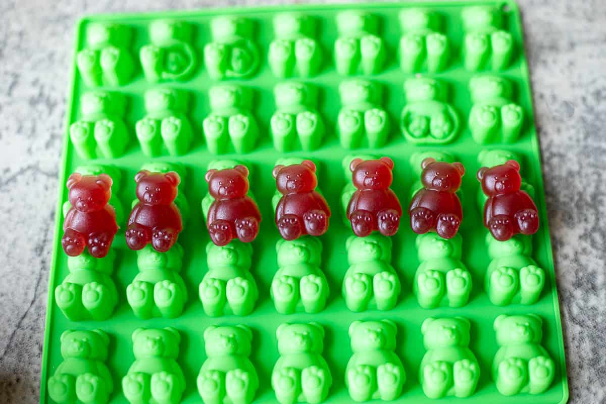 elderberry gummies on a green silicone bear tray. 
