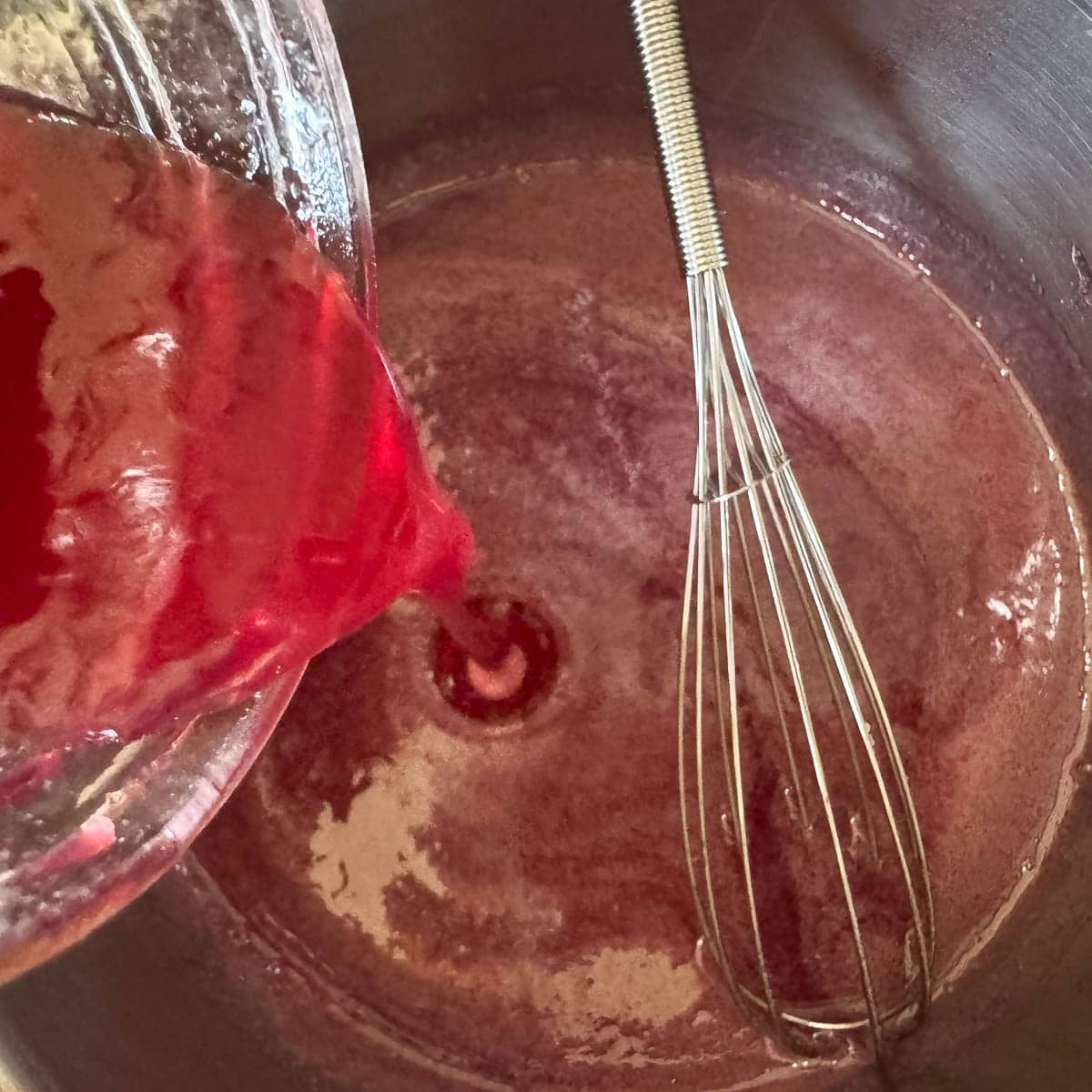 adding elderberry syrup to a pot.