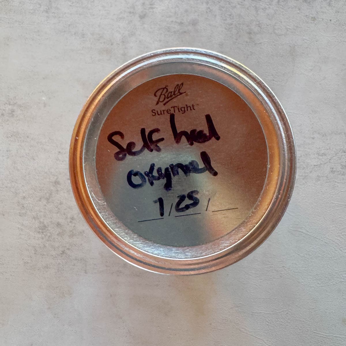 a mason jar with "selfheal oxymel" and the date writing on the lid. 