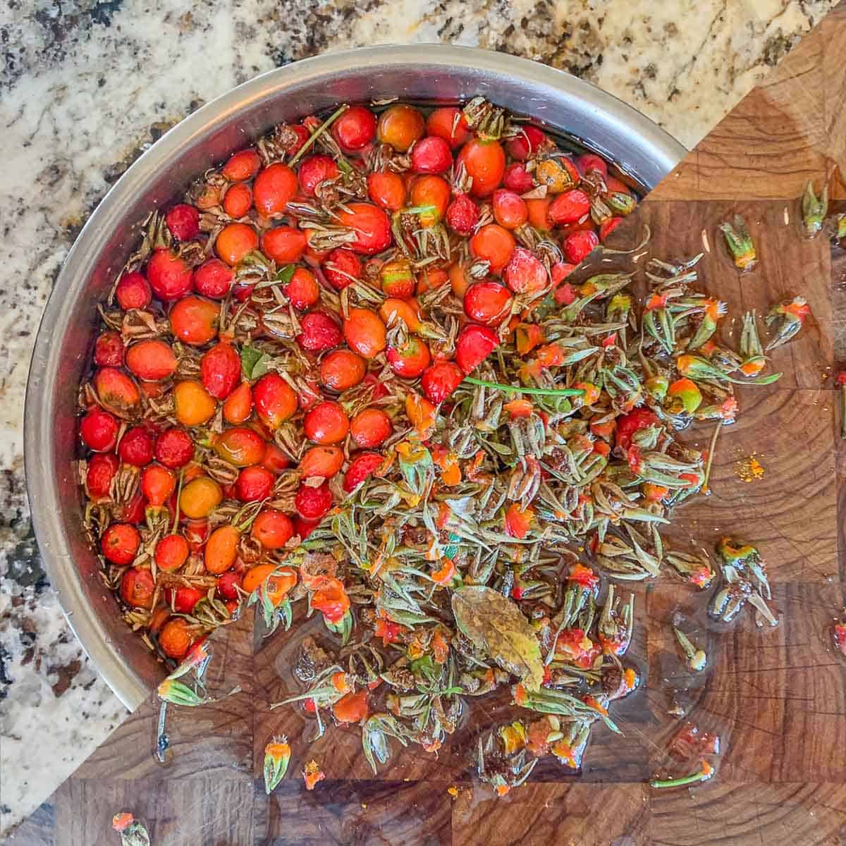 rosehips in a bowl and the dried part removed on a cutting board.
