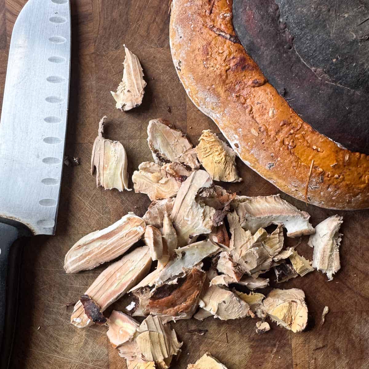 chopped red belted polypore on a cutting board.