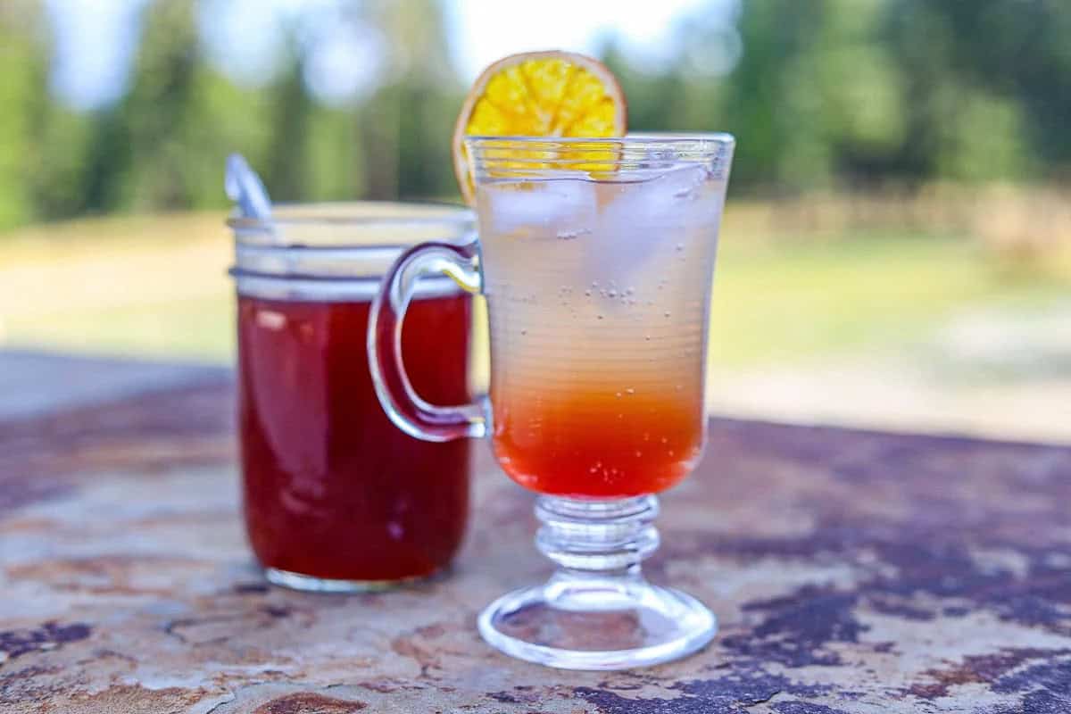 elderberry shrub in a jar and more in a glass with ice.