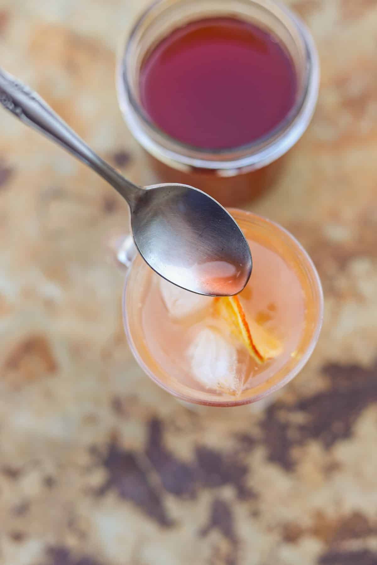 stirring shrub into an iced drink.