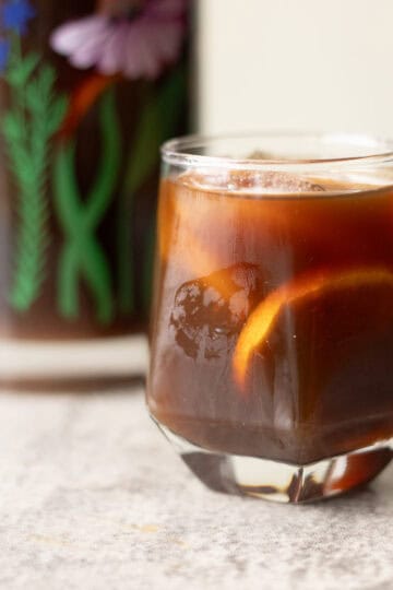 switchel drink in a glass with more in a pitcher.