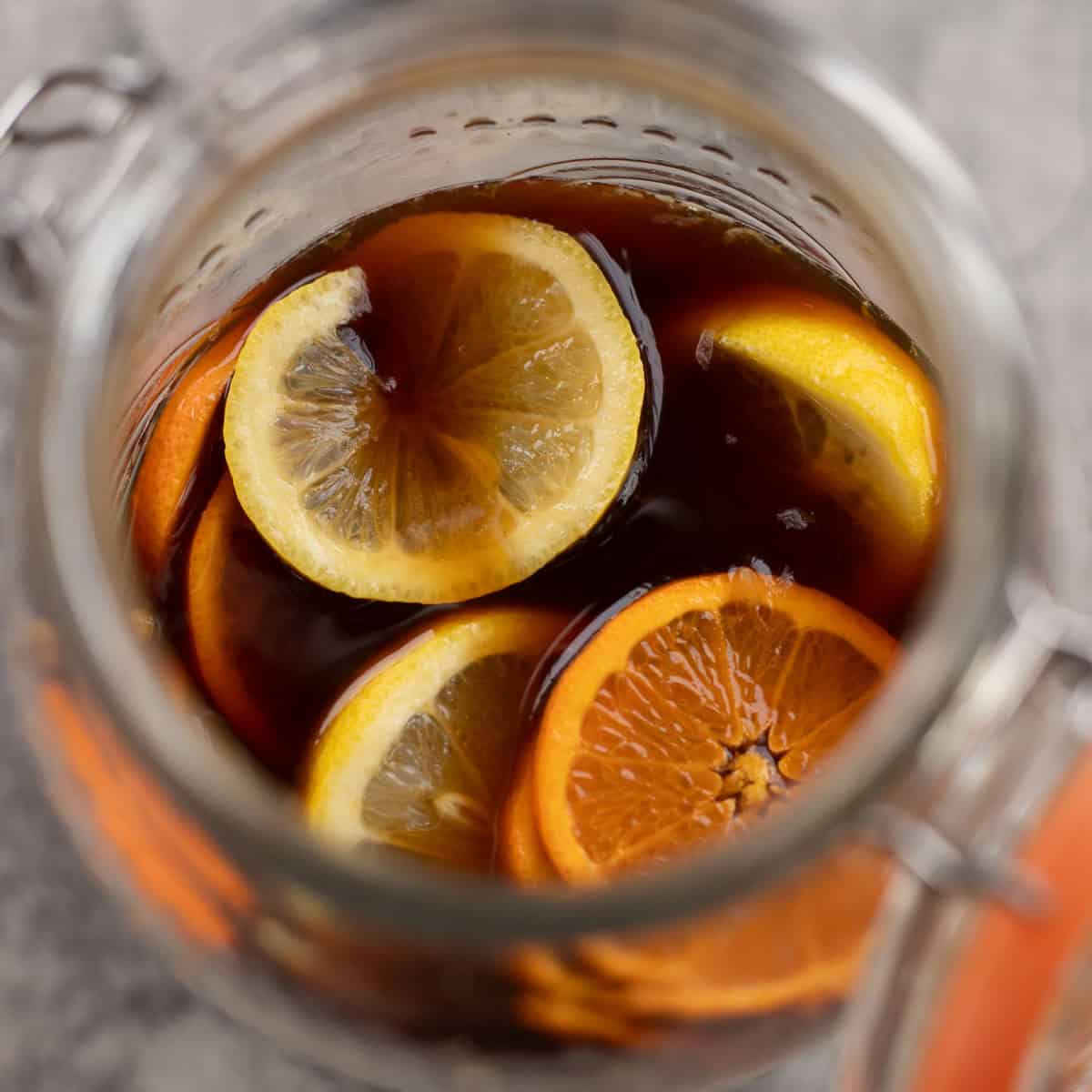 jar with switchel and sliced citrus.