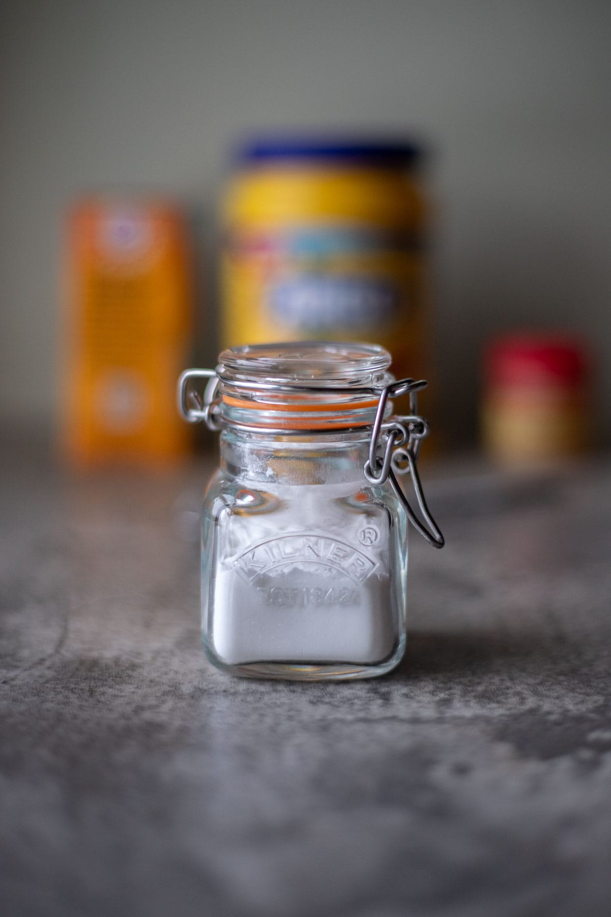 a jar of homemade baking powder with ingredients in the background.