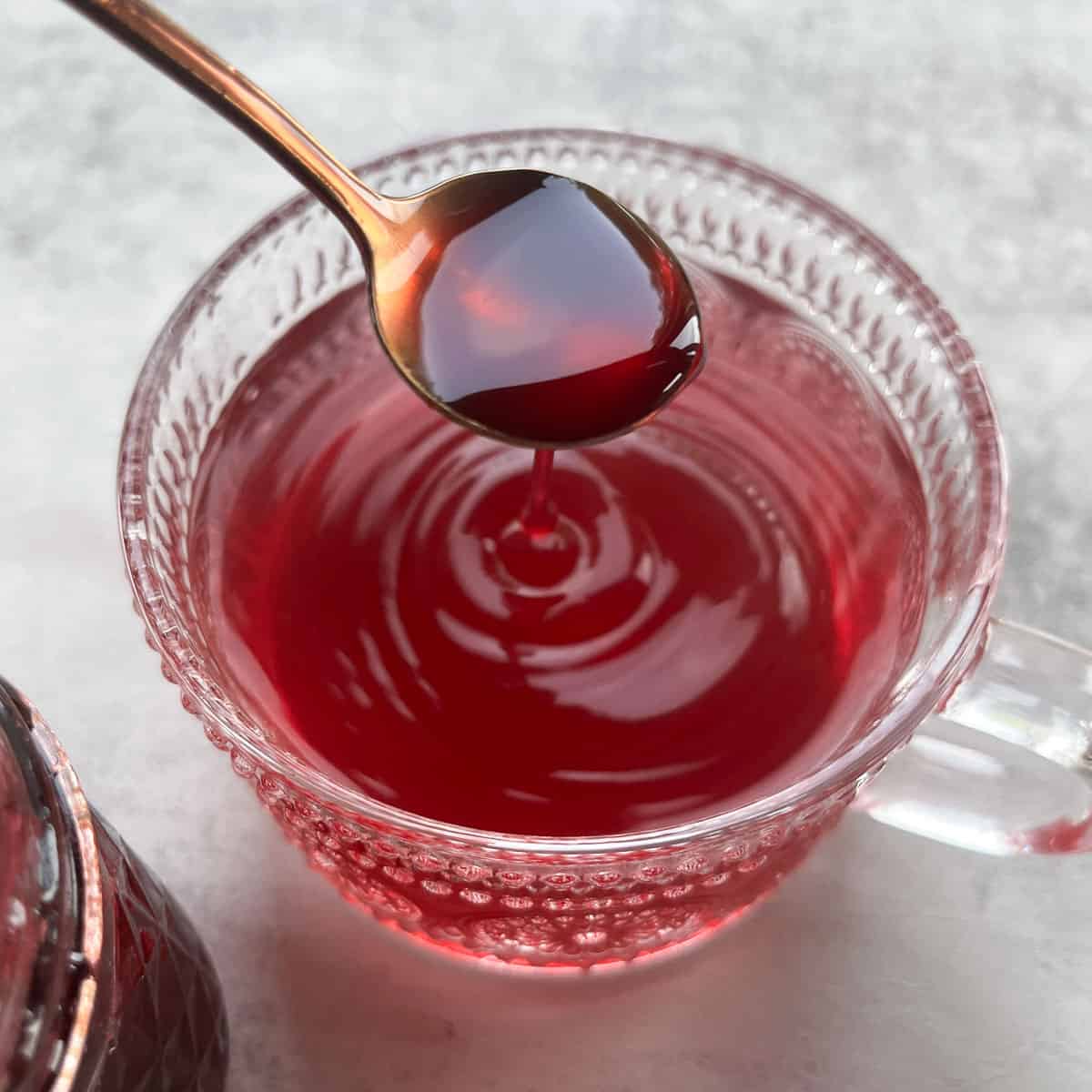 adding syrup to elderberry tea.