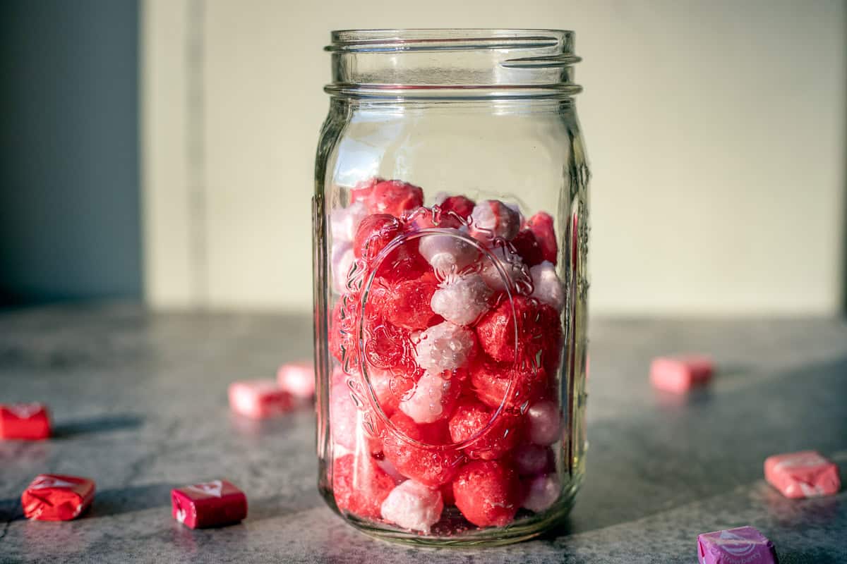 freeze dried skittles in a jar with more around them