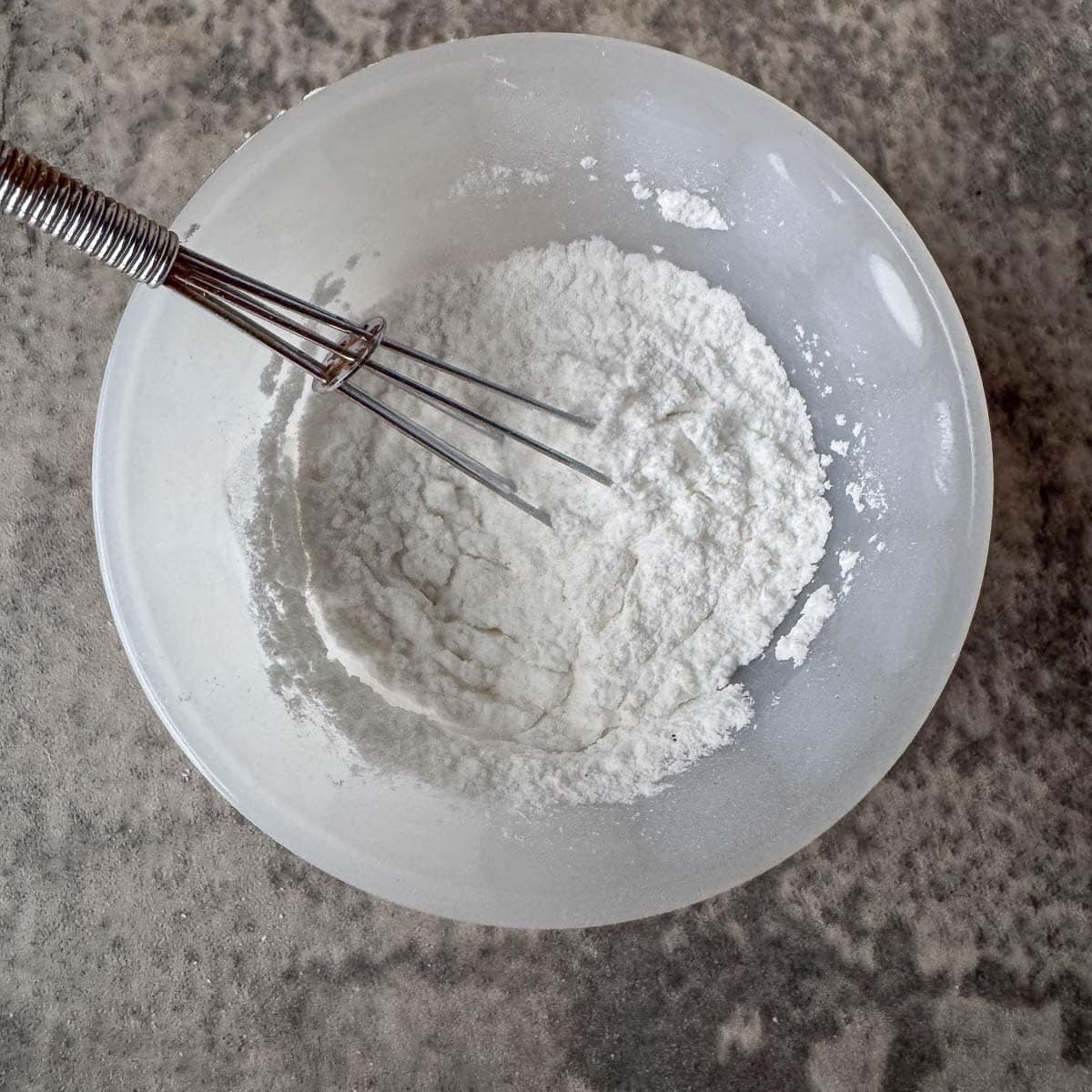 mixing homemade baking powder ingredients in a bowl.