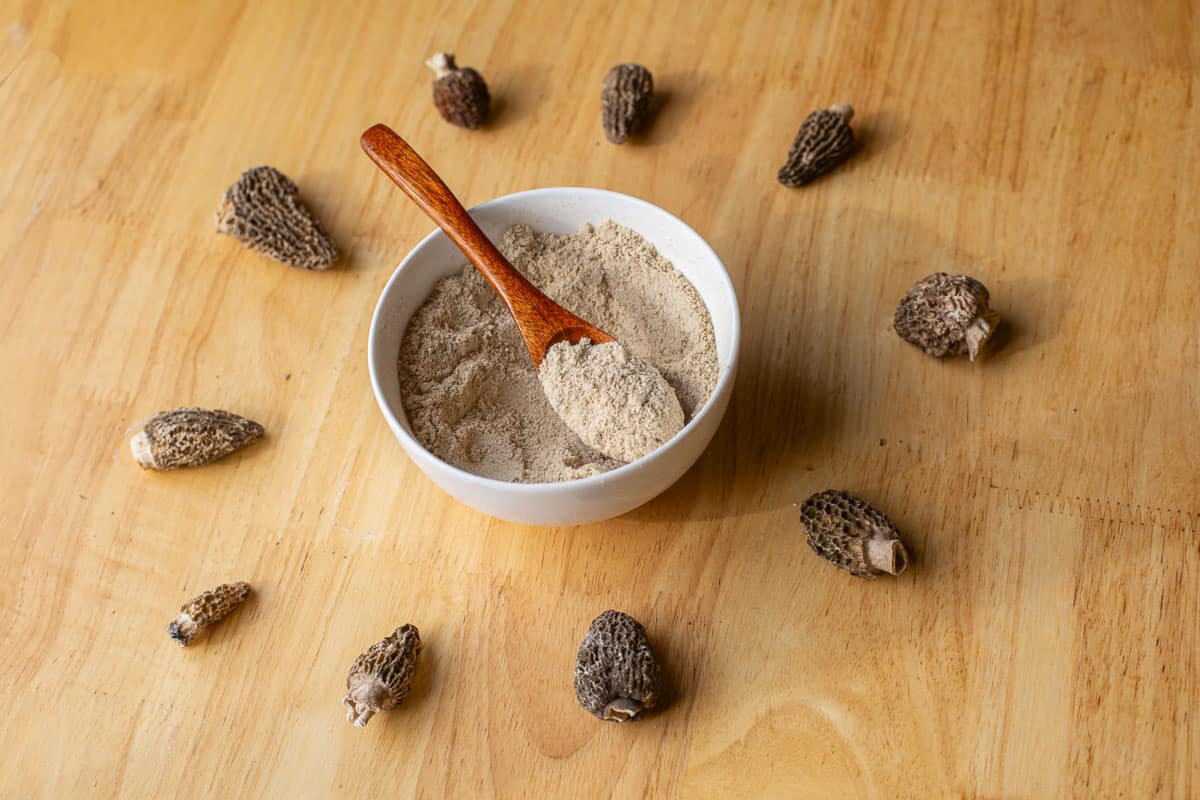 umami mushroom seasoning in a bowl with morels around it