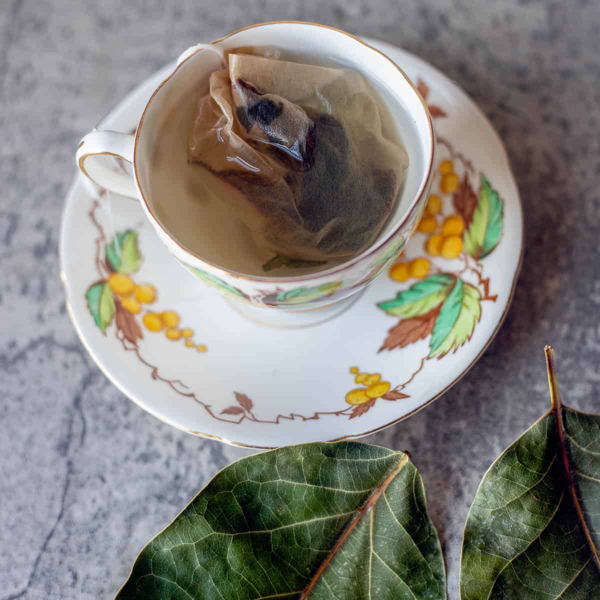 avocado leaf tea with some dried avocado leaves next to it