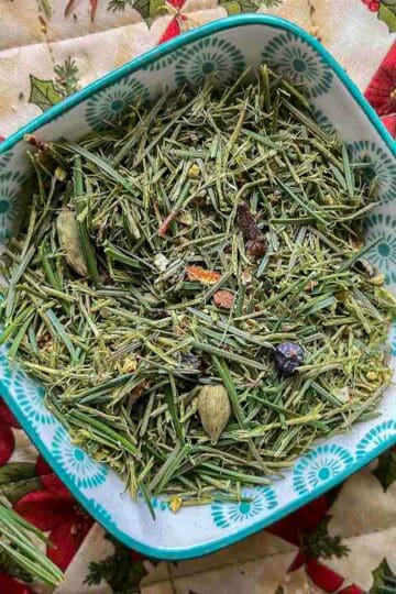 pine needle tea blend in a bowl with pine needles around it