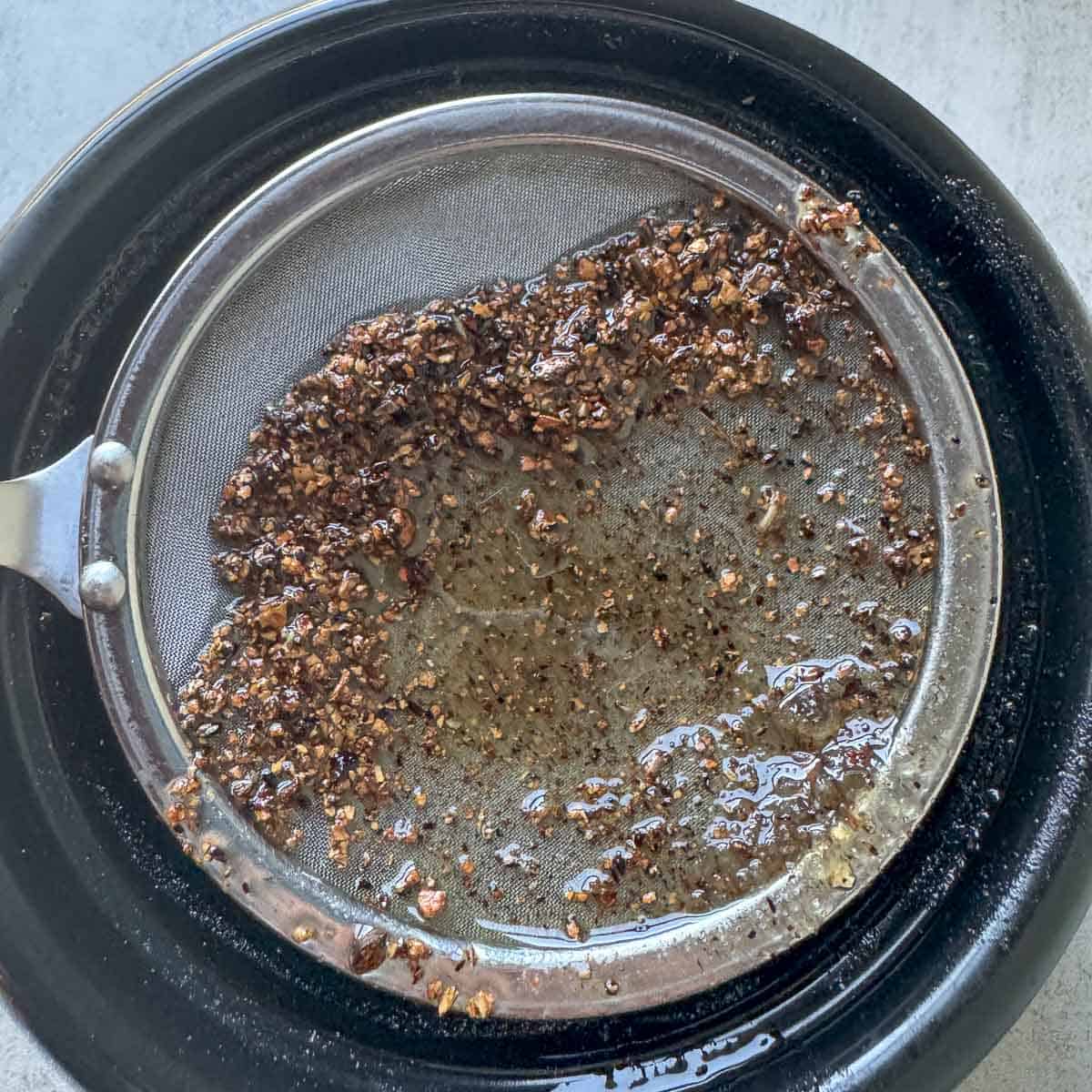 using a skimmer to remove wood particles from salve resin oil