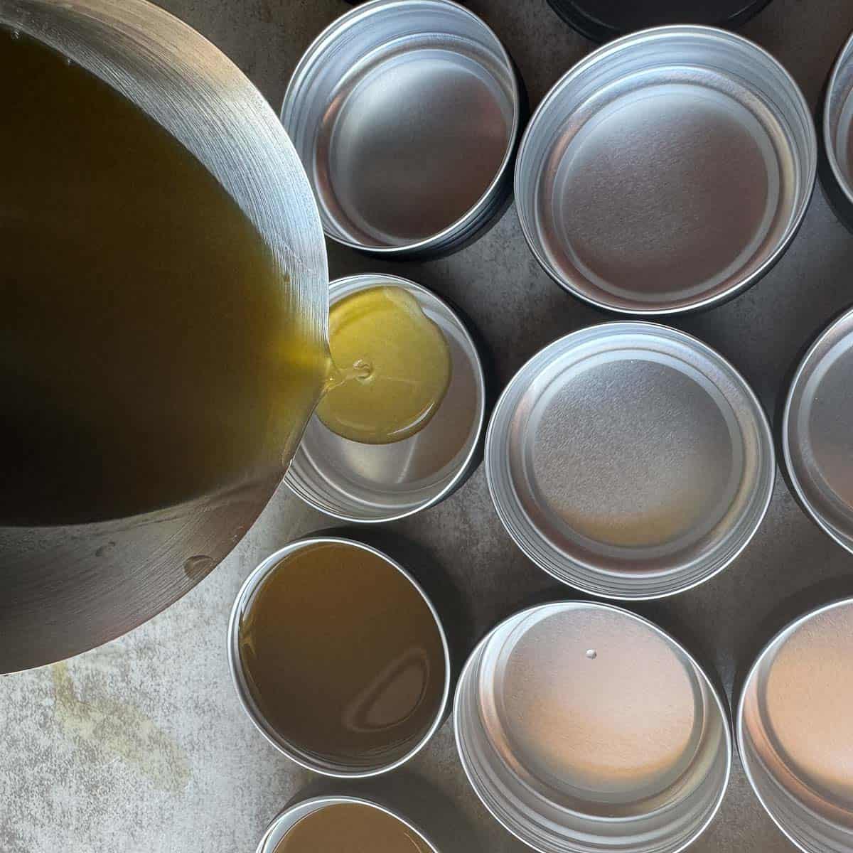 pouring liquid pine resin salve into tins