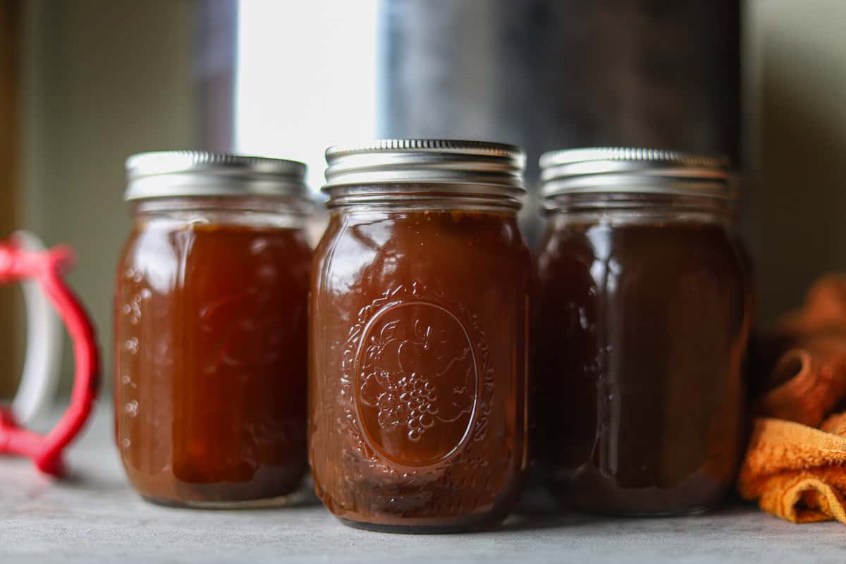 bone broth in jars with pressure cooker behind it