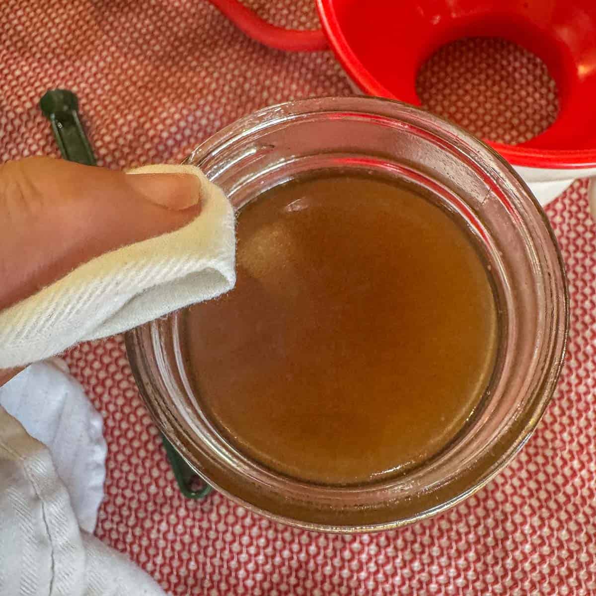 wiping jar rims of bone broth with vinegar