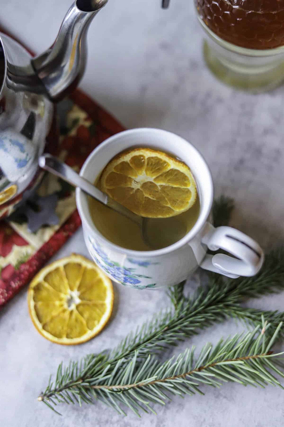 a cup of pine needle tea with orange slices