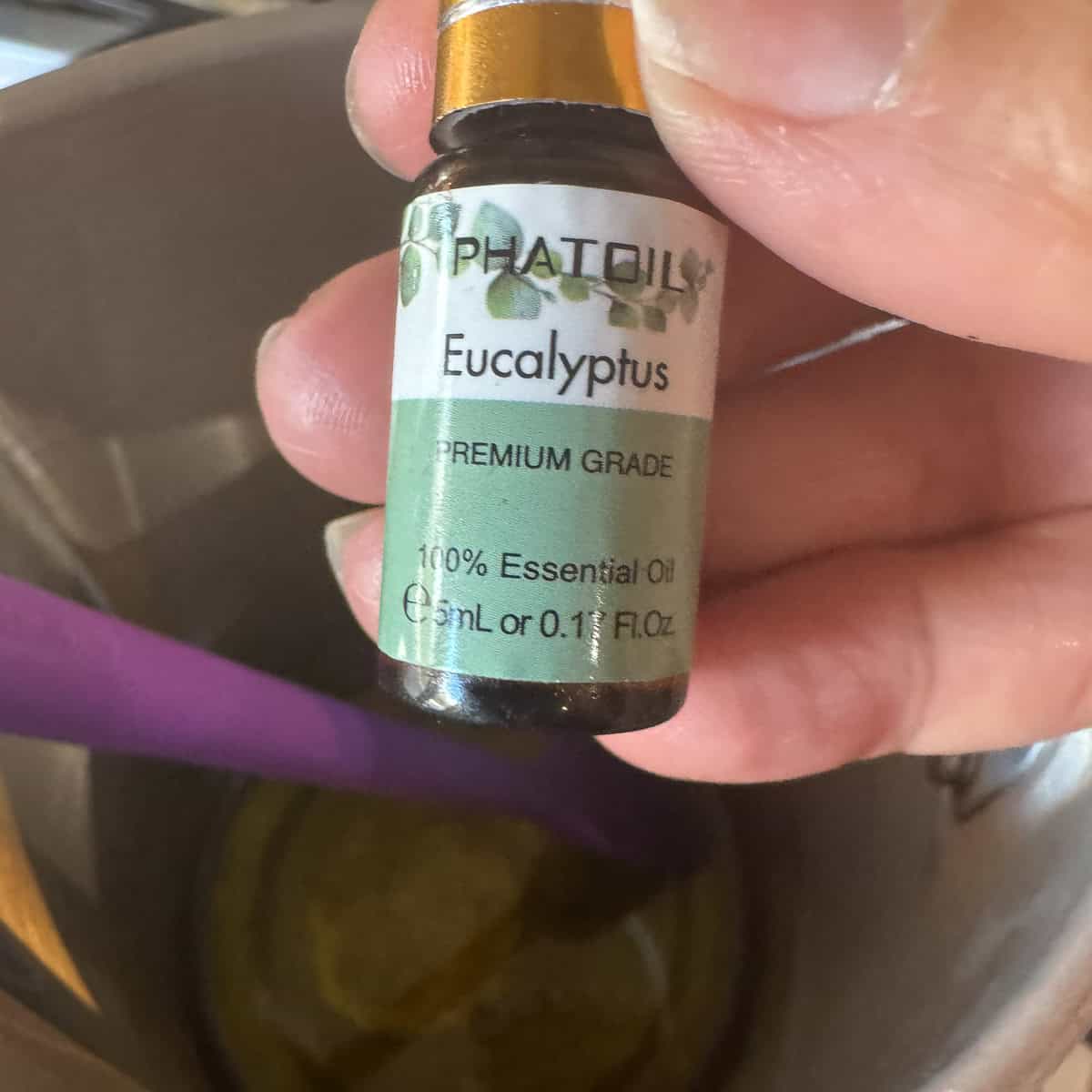 eucalyptus essential oil about to be poured in tallow balm mixture