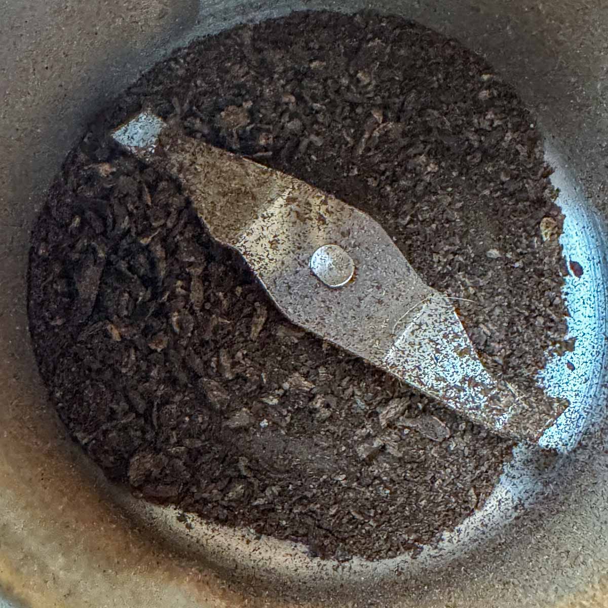roasted dandelion root beying ground in a coffee grinder