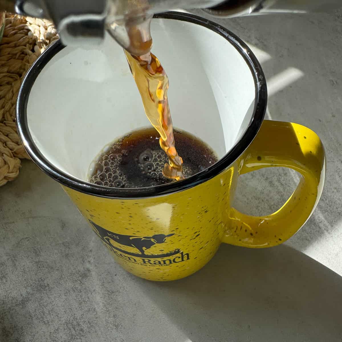 pouring dandelion coffee into a yellow mug