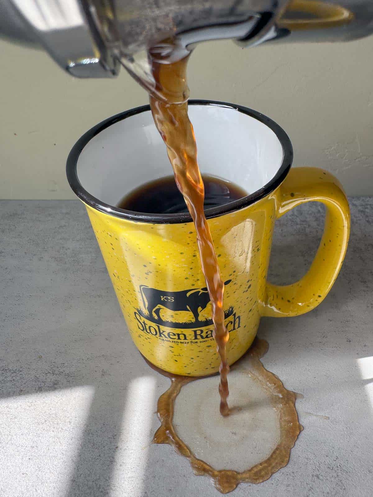 pouring dandelion coffee next to a cup half full of dandelion coffee
