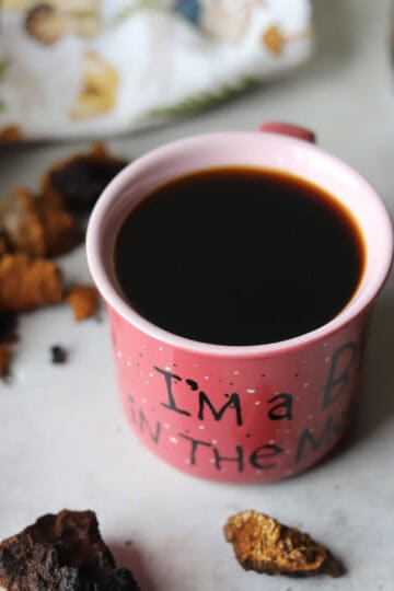 chaga coffee in a mug with more chaga around it