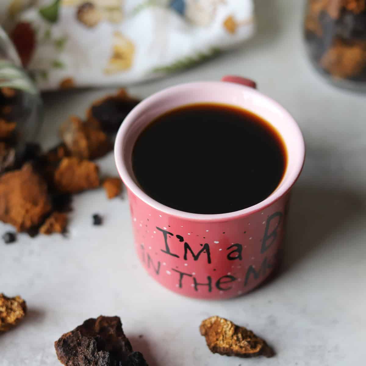 chaga coffee in a mug with more chaga around it