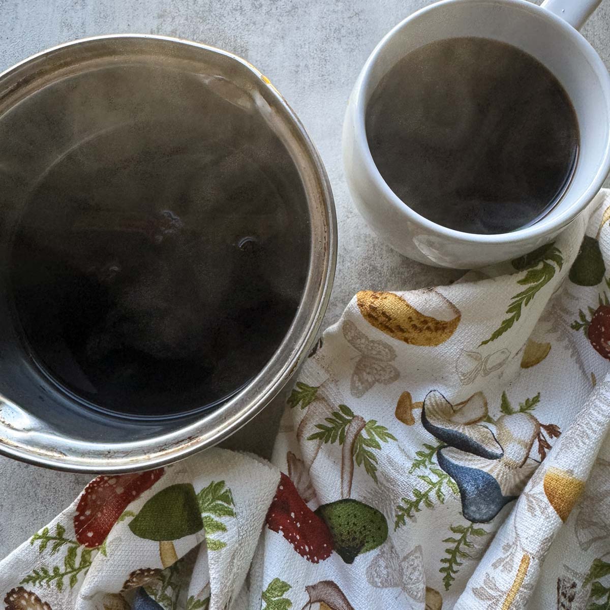 a cup of chaga coffee with more in a saucepan next to it