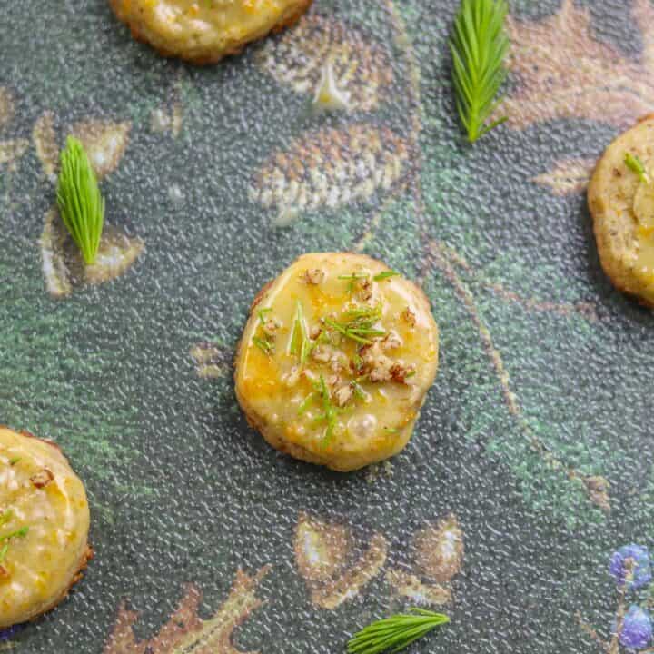 spruce tip cookies with spruce tips scattered around them