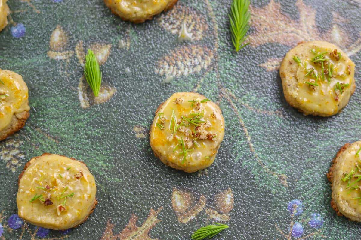 spruce tip cookies garnished with chopped spruce tips and ground nuts