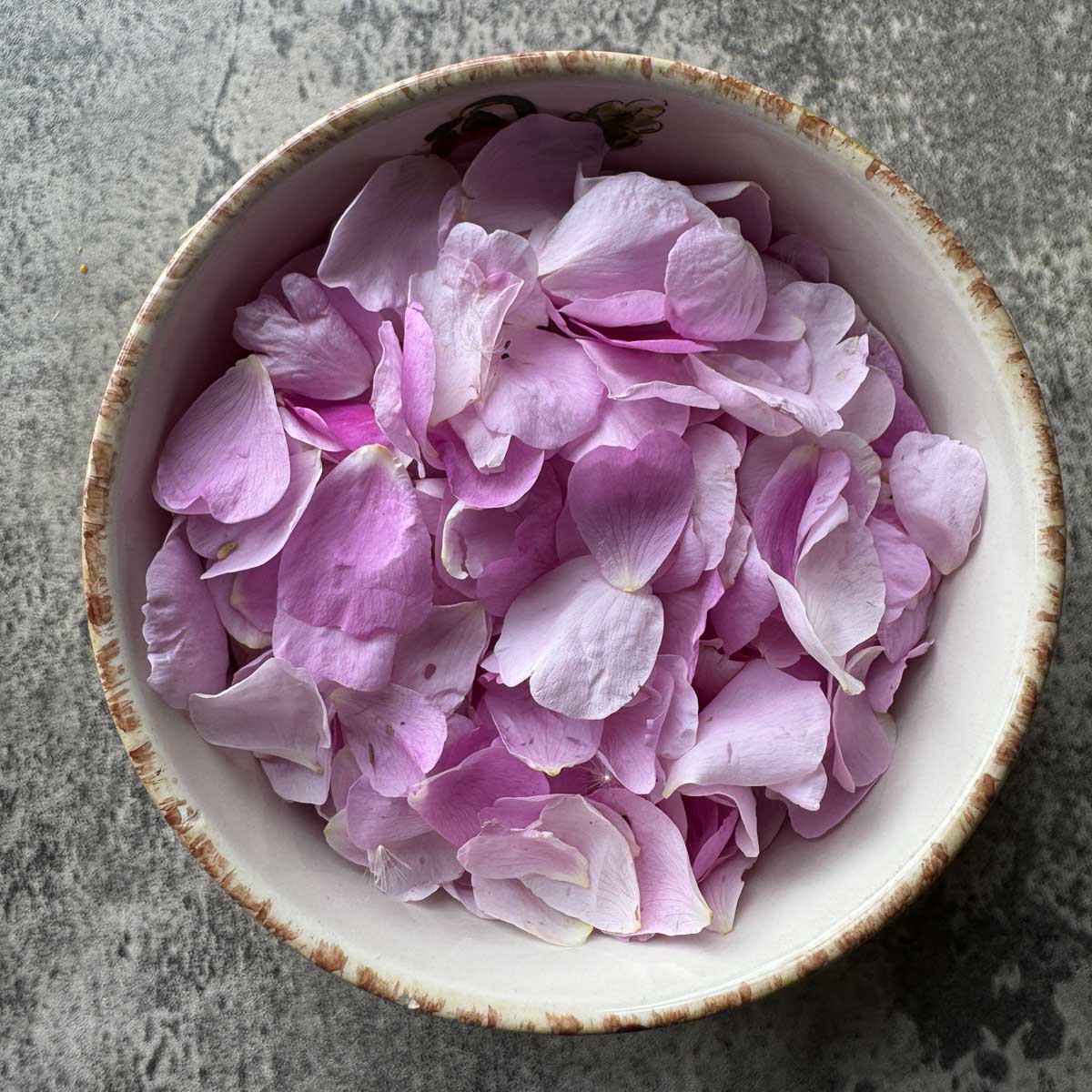 a bowl full of pink rose petals