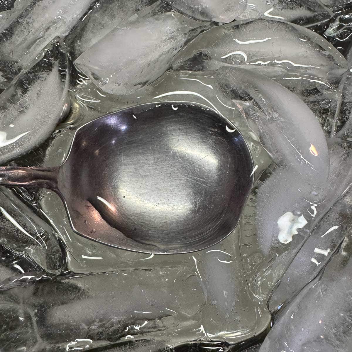 melting ice with a silver spoon in the center filled with water