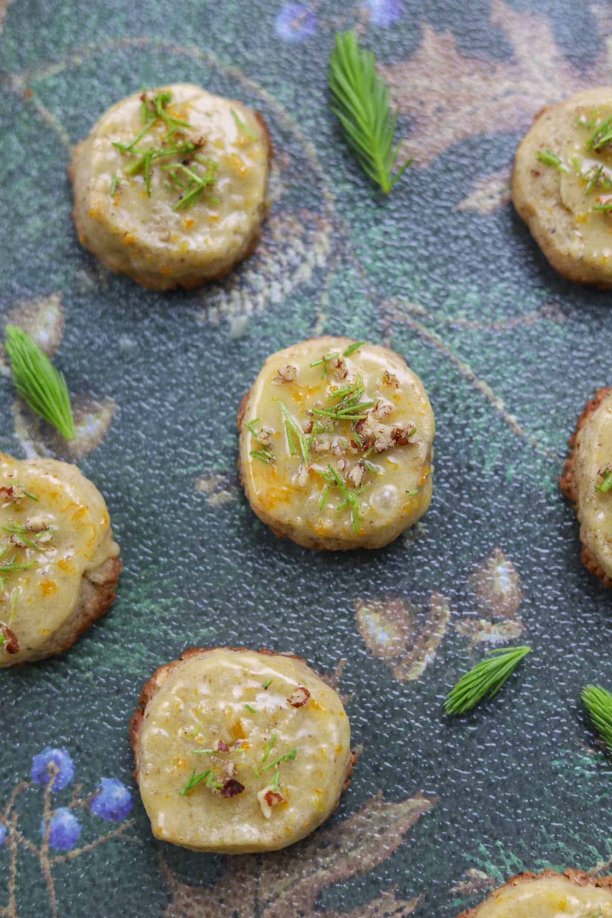 spruce tip cookies with spruce tips around them