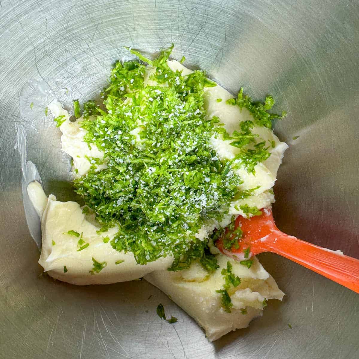 minced garlic scapes and butter in a mixing bowl