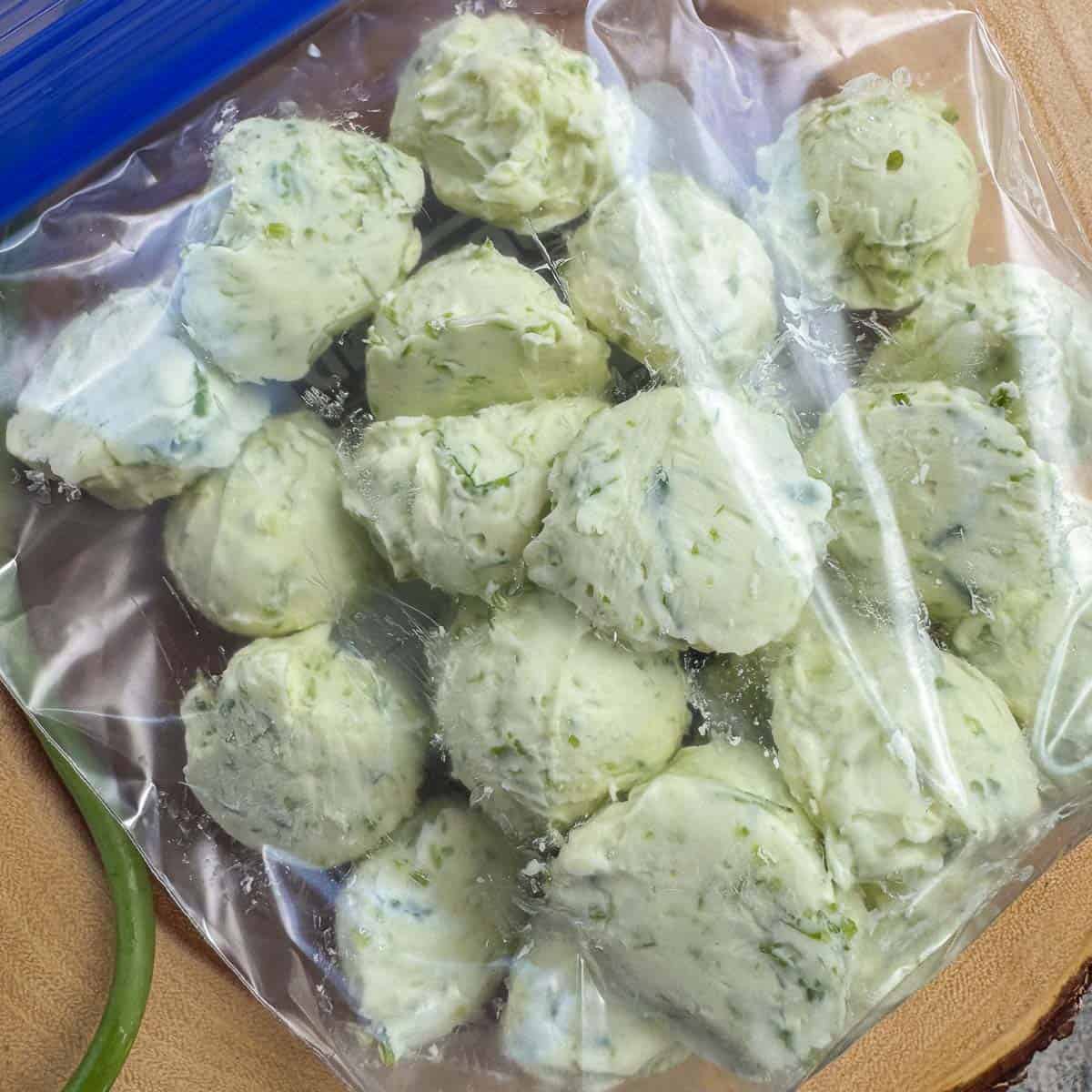 frozen scoops of garlic scape butter in a ziploc bag