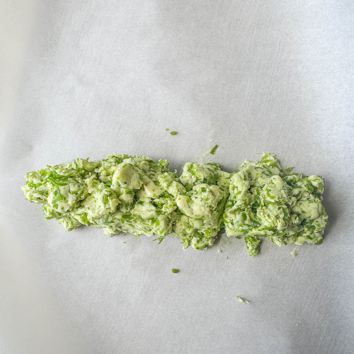 log of garlic scape butter on parchment paper