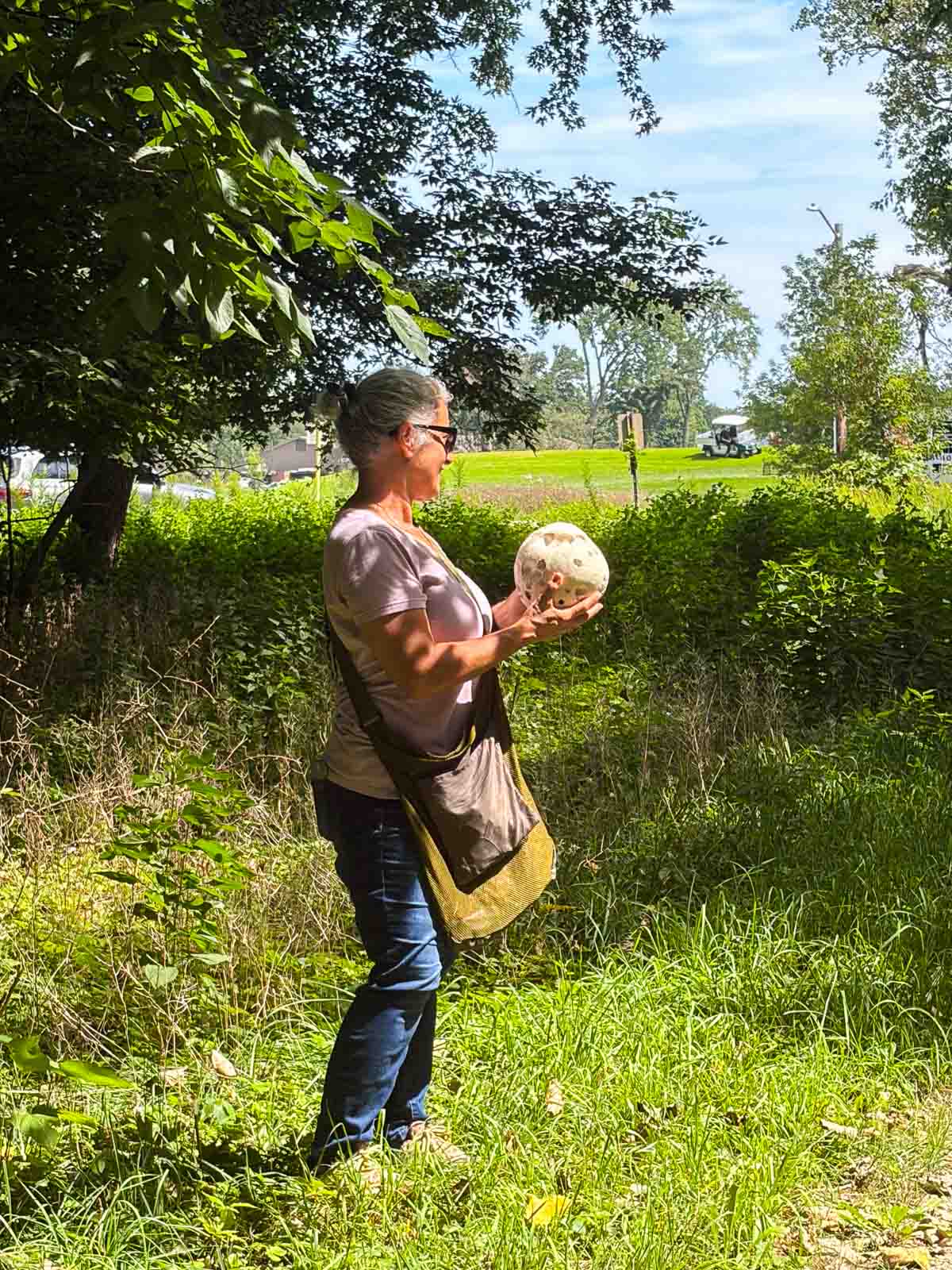 a lady holding a giant puffball mushroom