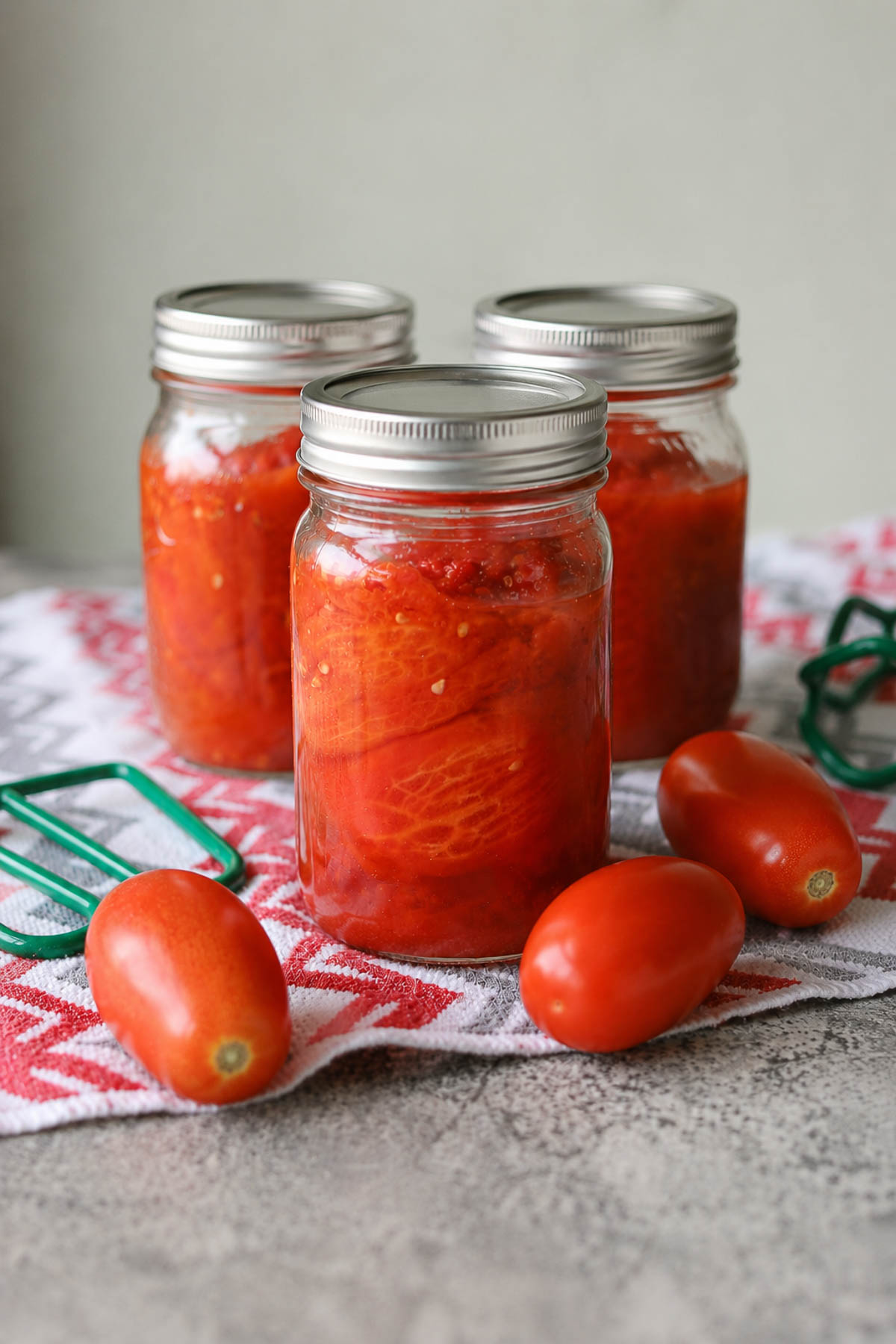 pressure canned tomatoes with tomatoes around the jars