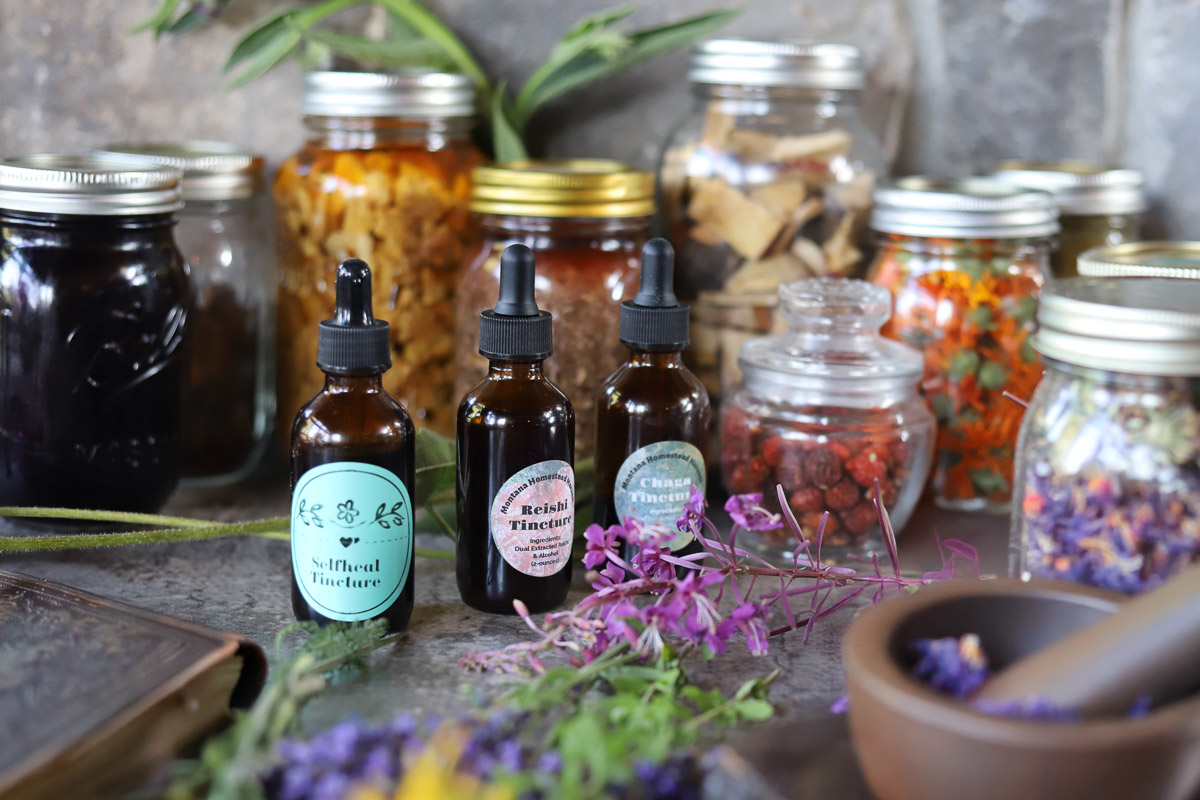 tinctures and herbs in mason jars, amber bottles and a mortar and pestle (Spagyric Method)