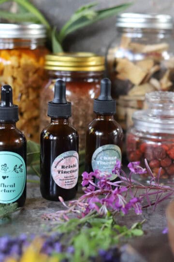 tinctures and herbs in mason jars, amber bottles and a mortar and pestle