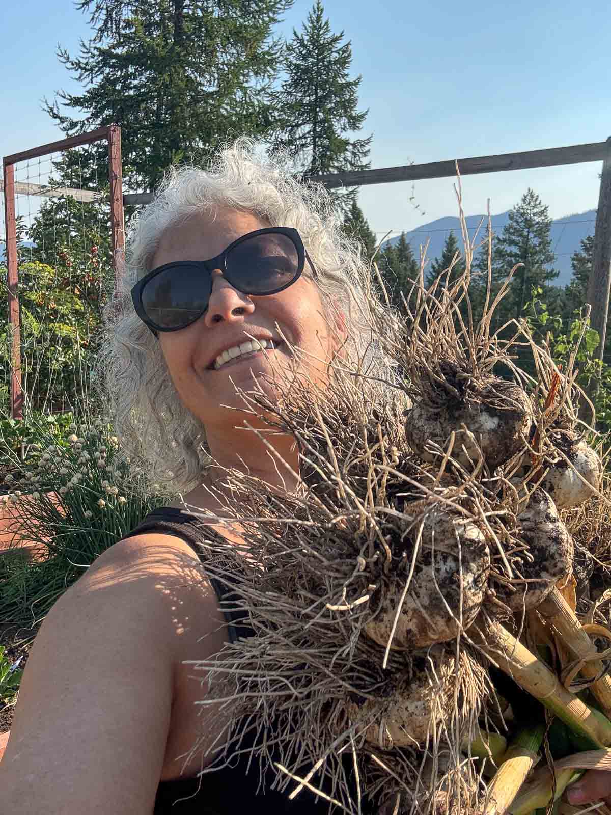 woman with harvested garlic in her arms