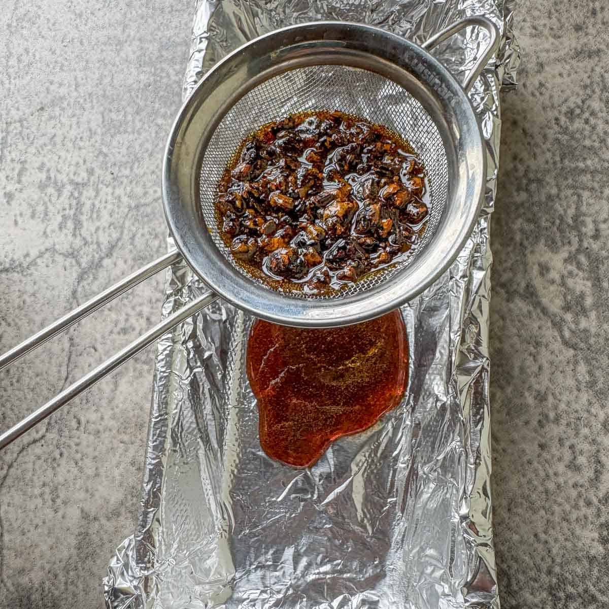pine resin being strained through a small strainer