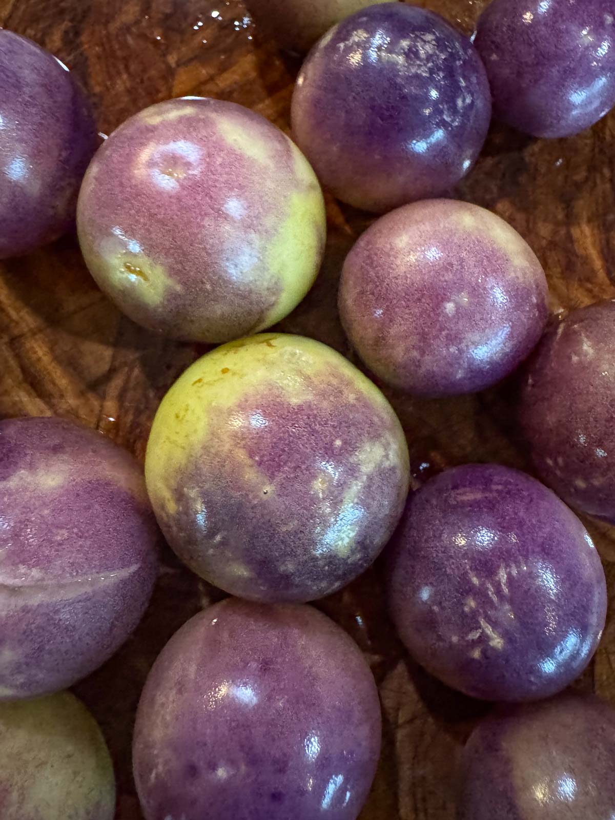 purple tomatillos on a cutting board