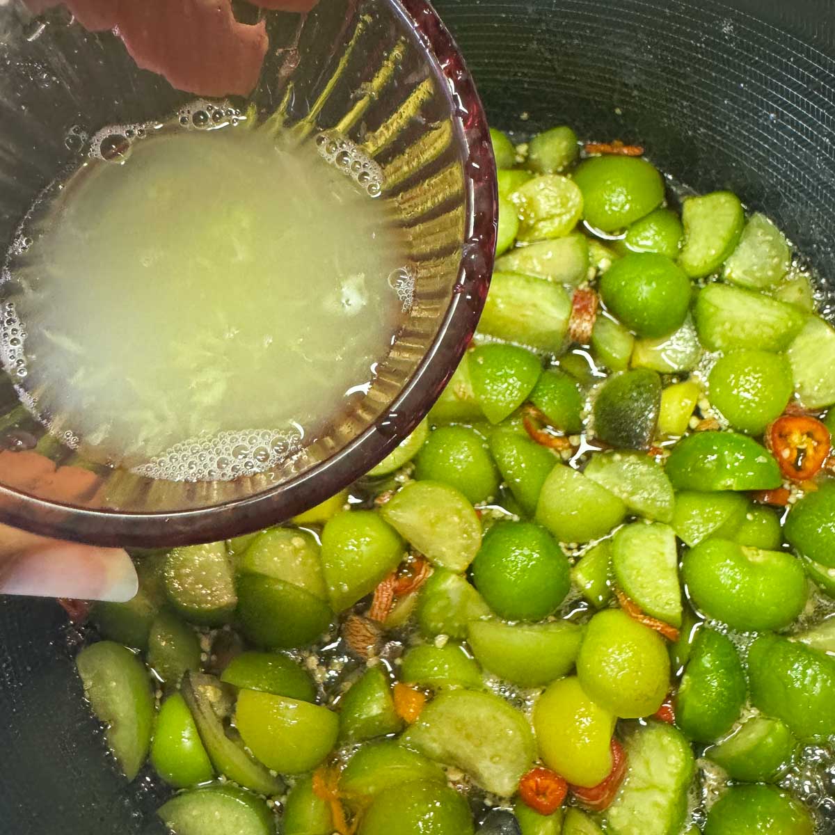 lime juice being added to tomatillo jam
