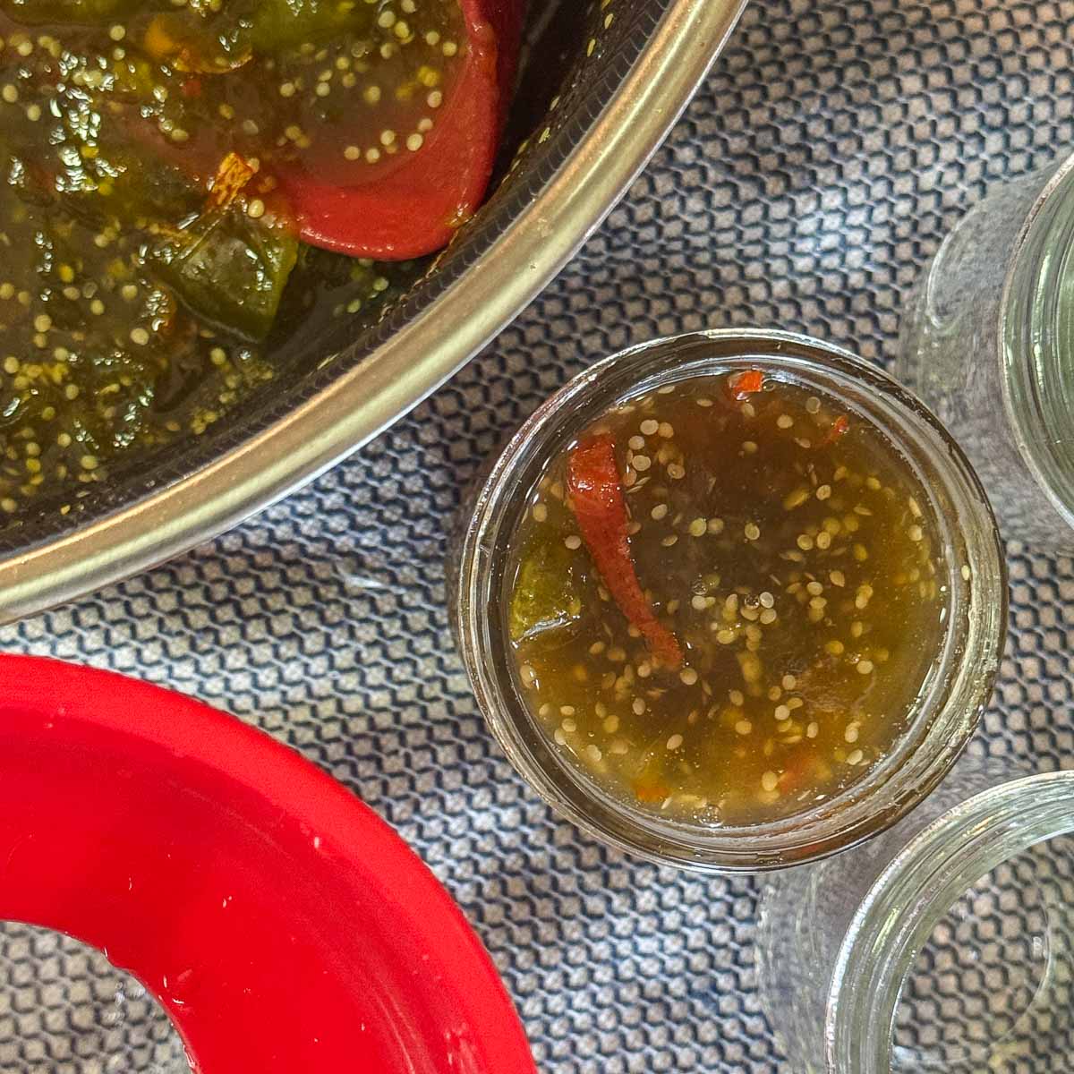 tomatillo jam in a jar with more in a pot next to it